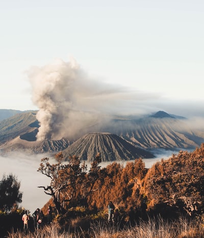 站在有火山背景的悬崖上的人